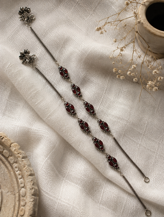 Decorative hairpin with maroon stones on a textured beige fabric background