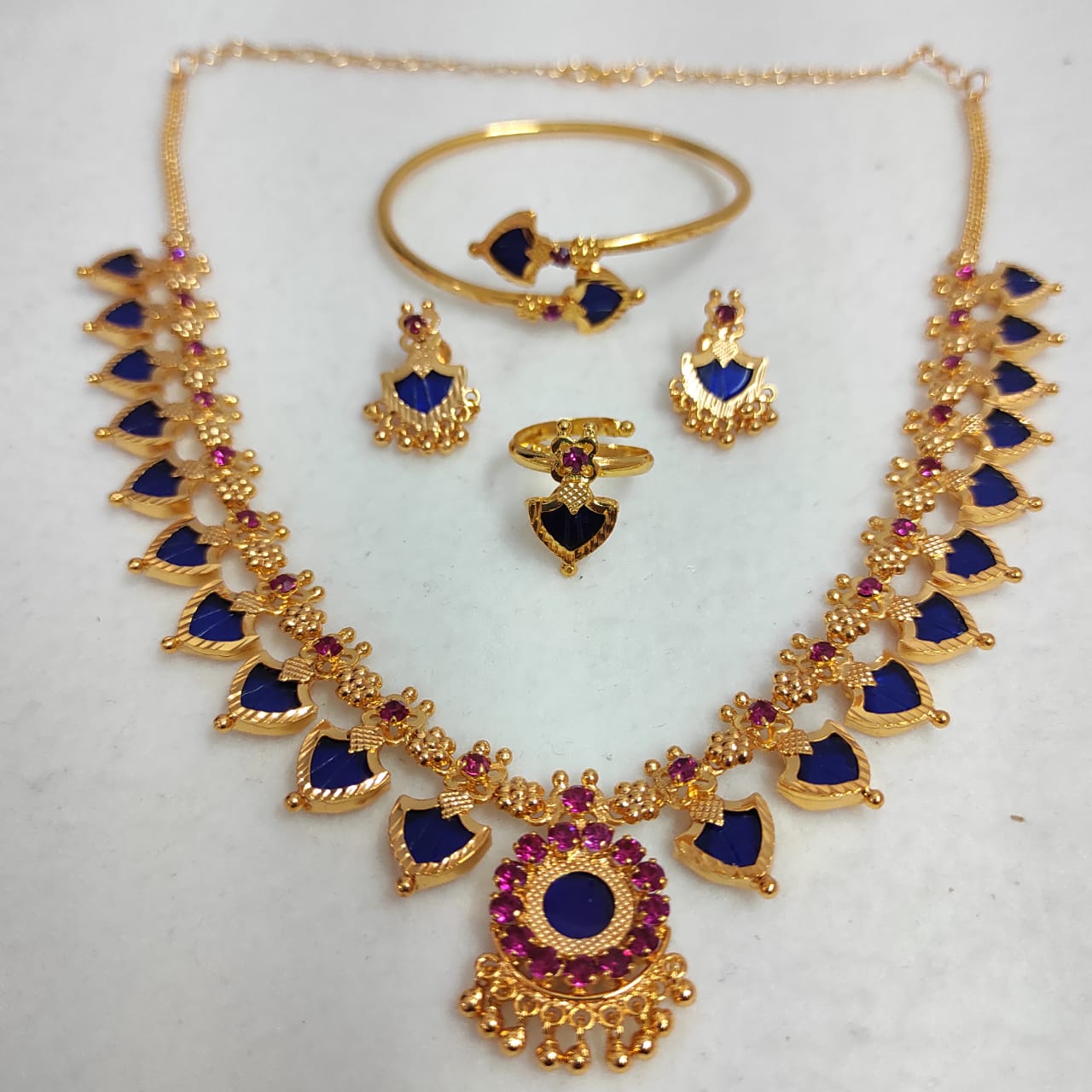 Jewelry set with necklace, earrings, ring, and bracelet on a white background