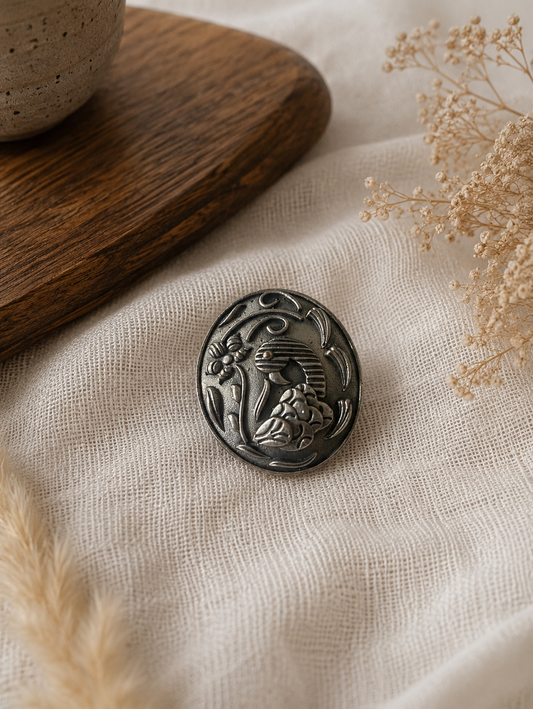 Decorative hair pin with intricate design on a textured fabric surface