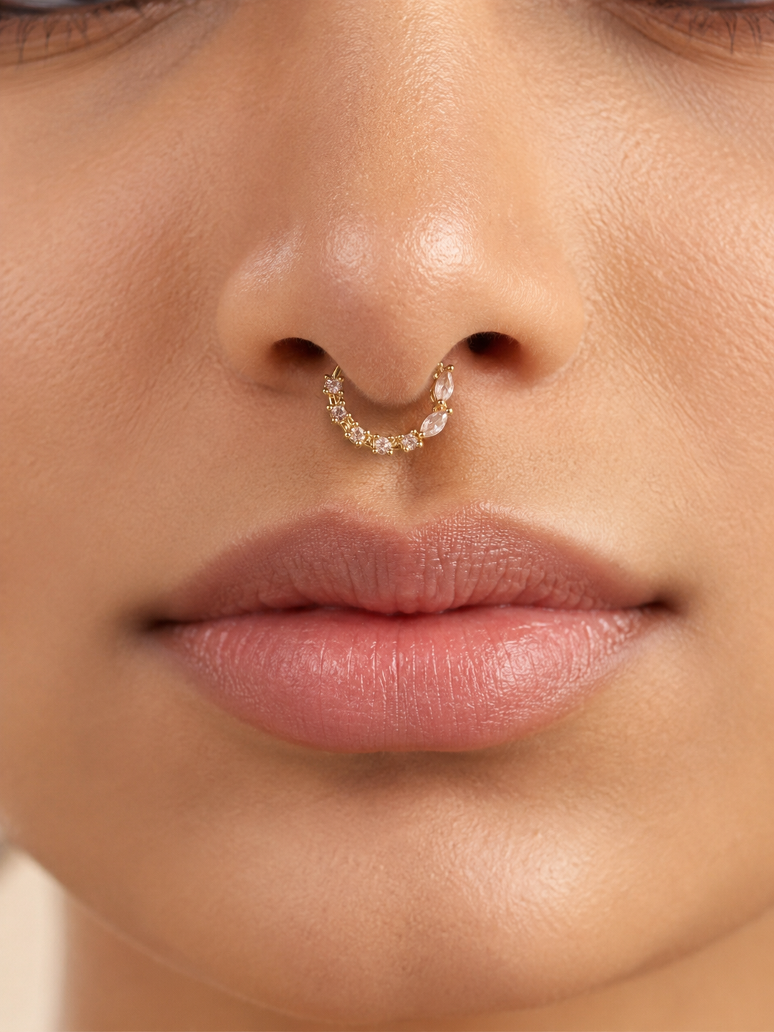 Close-up view of a model wearing the gold-tone festive nose ring as a septum ring, highlighting the unique layout of sparkling round and marquise-cut stones.