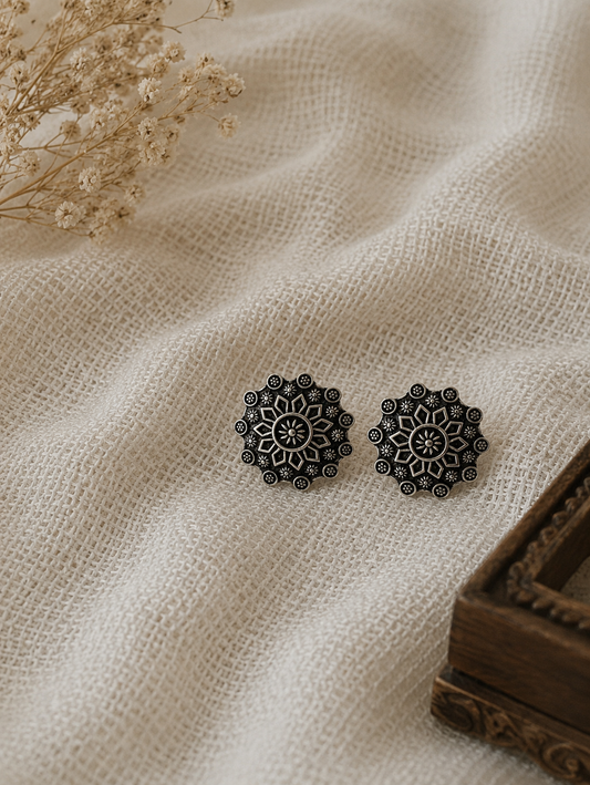 circular oxidized silver toe rings featuring an intricate floral mandala design, on a off white cloth