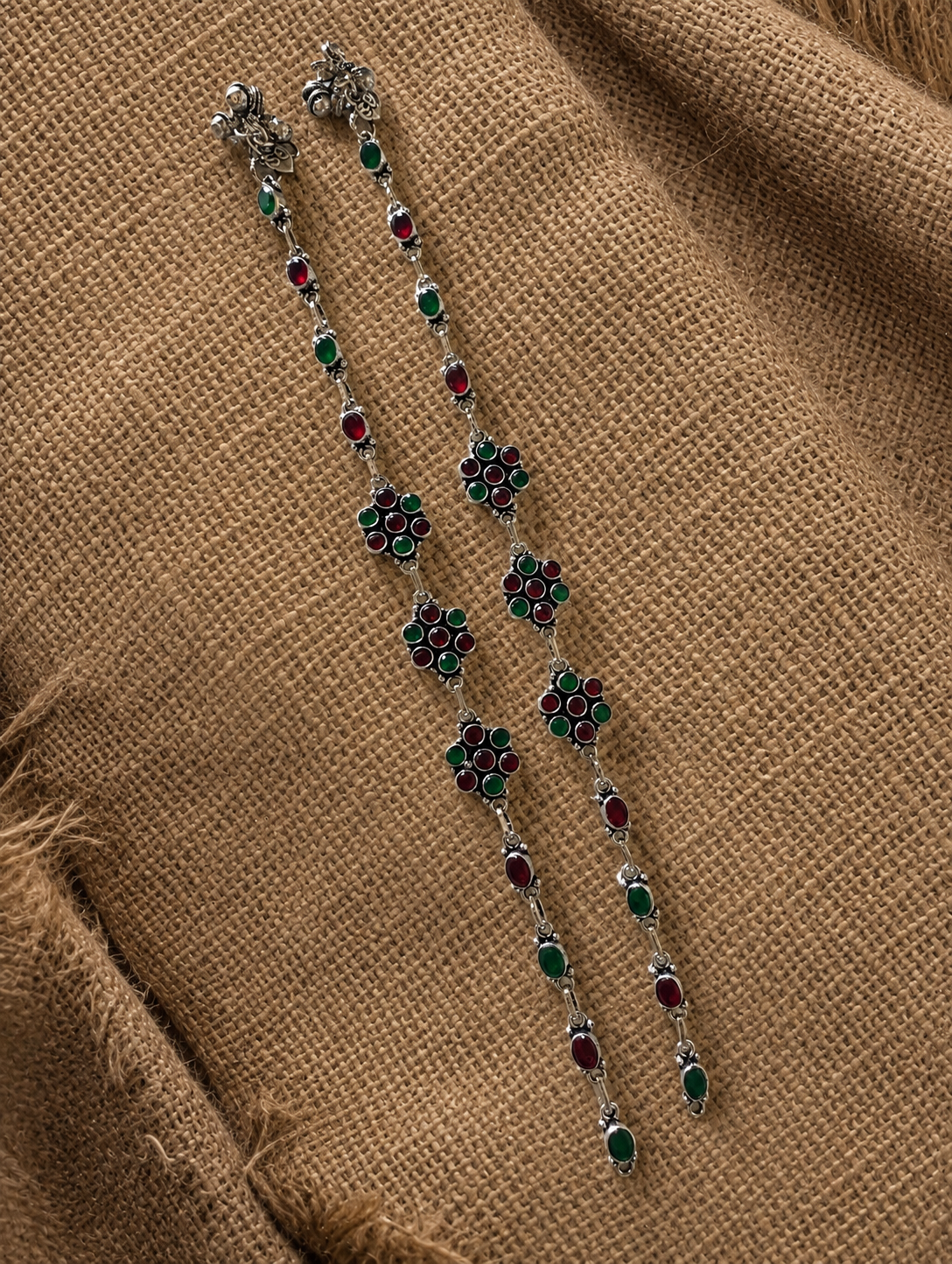 Decorative necklace with floral designs on a brown fabric background