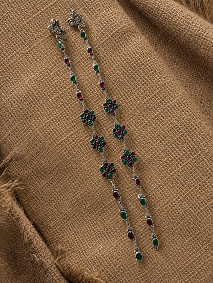 Decorative necklace with floral designs on a brown fabric background
