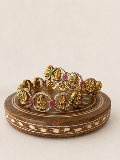 Gold jewelry set on a wooden stand with a beige background
