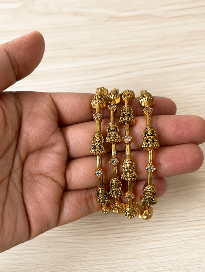 Gold jewelry set held in a hand on a light wooden surface