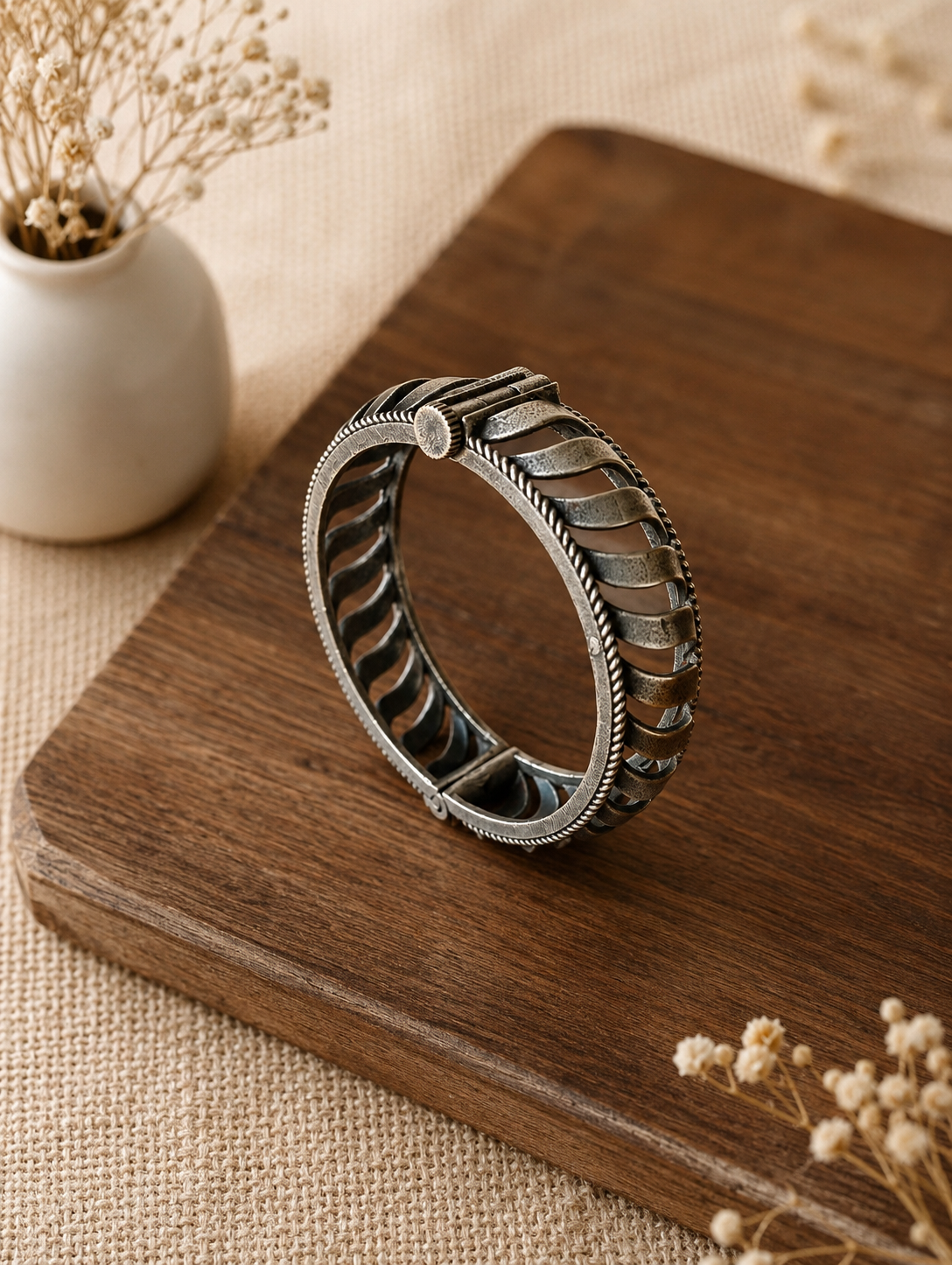 Silver bracelet with intricate design on a wooden surface