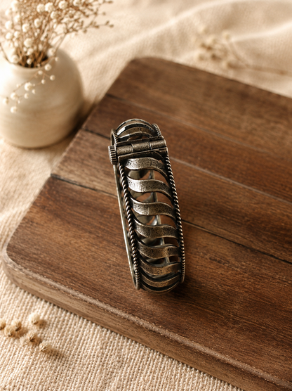 Decorative metal hair clip on a wooden surface with a soft focus background