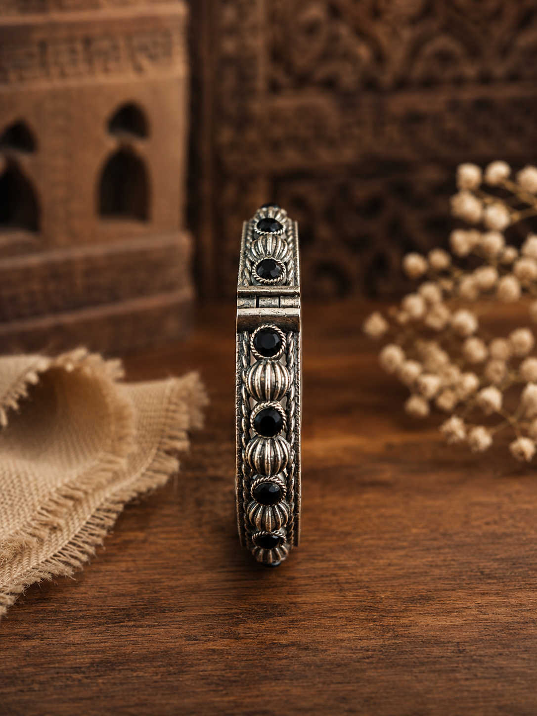 Decorative bracelet with black stones on a wooden surface
