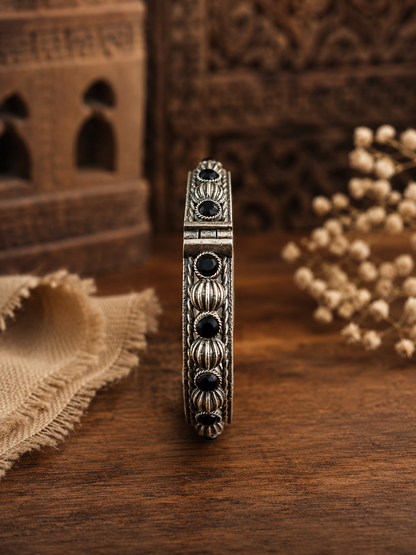 Decorative bracelet with black stones on a wooden surface
