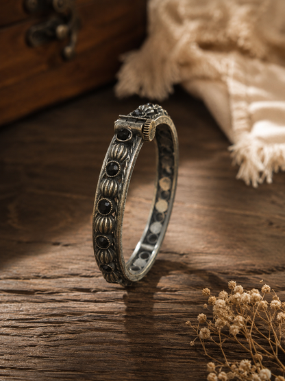 Silver bracelet with black stones on a wooden surface