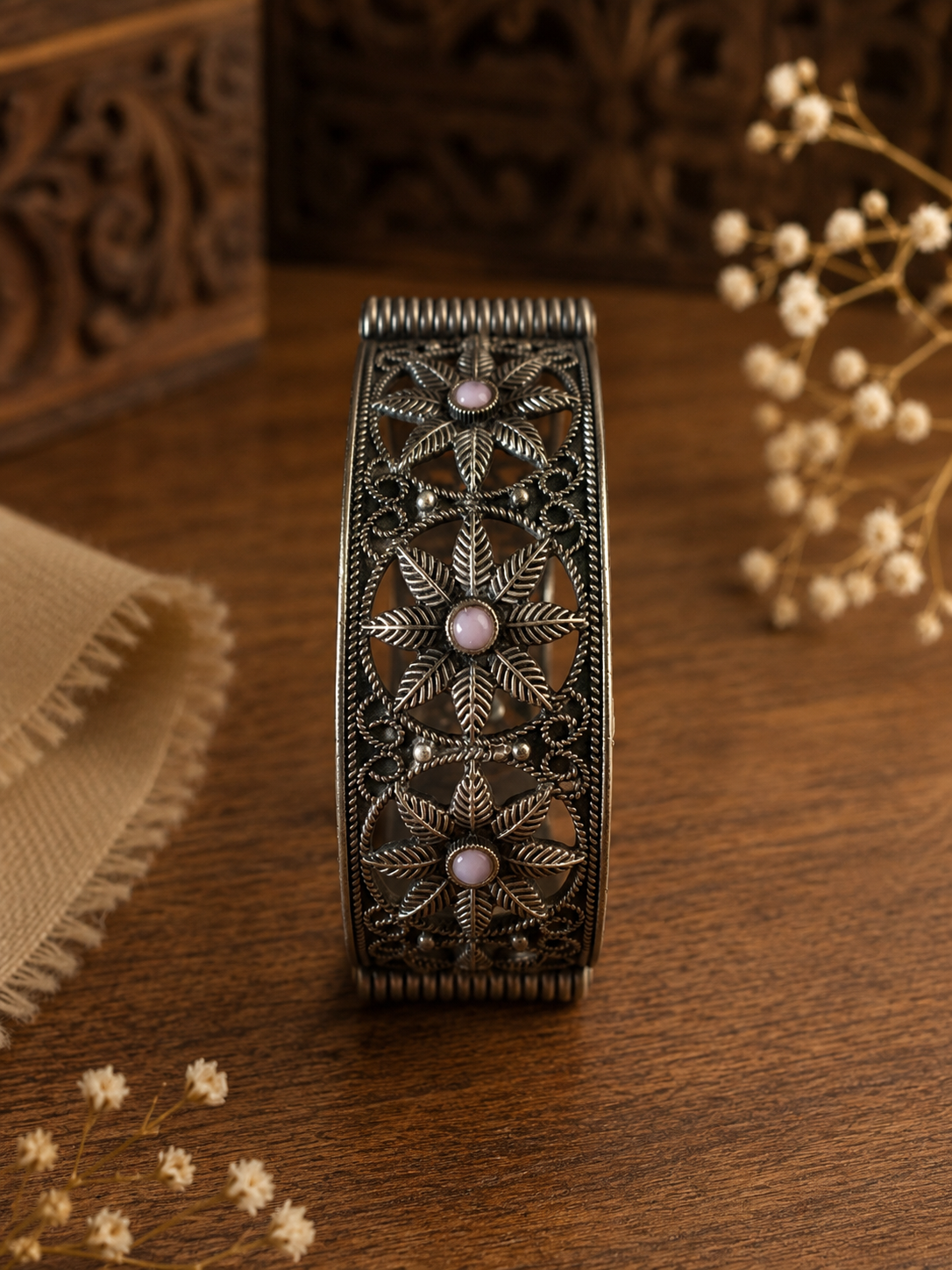 Decorative bracelet with intricate patterns on a wooden surface