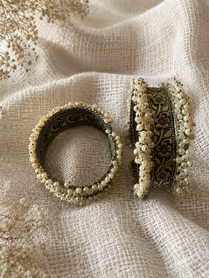 Decorative bangles with floral patterns on a textured fabric background