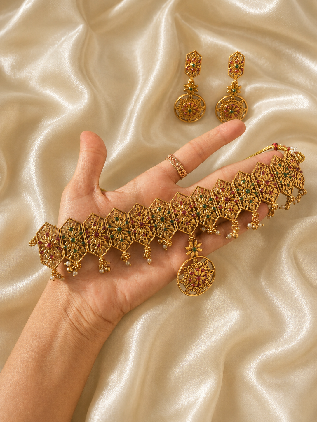 A slender and minimalist gold-plated choker necklace displayed on a cream satin background, featuring a row of small, brilliant circular white CZ stones closely aligned in a modern, dainty layout.