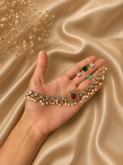 Hand holding a bracelet with various gemstones on a gold fabric background