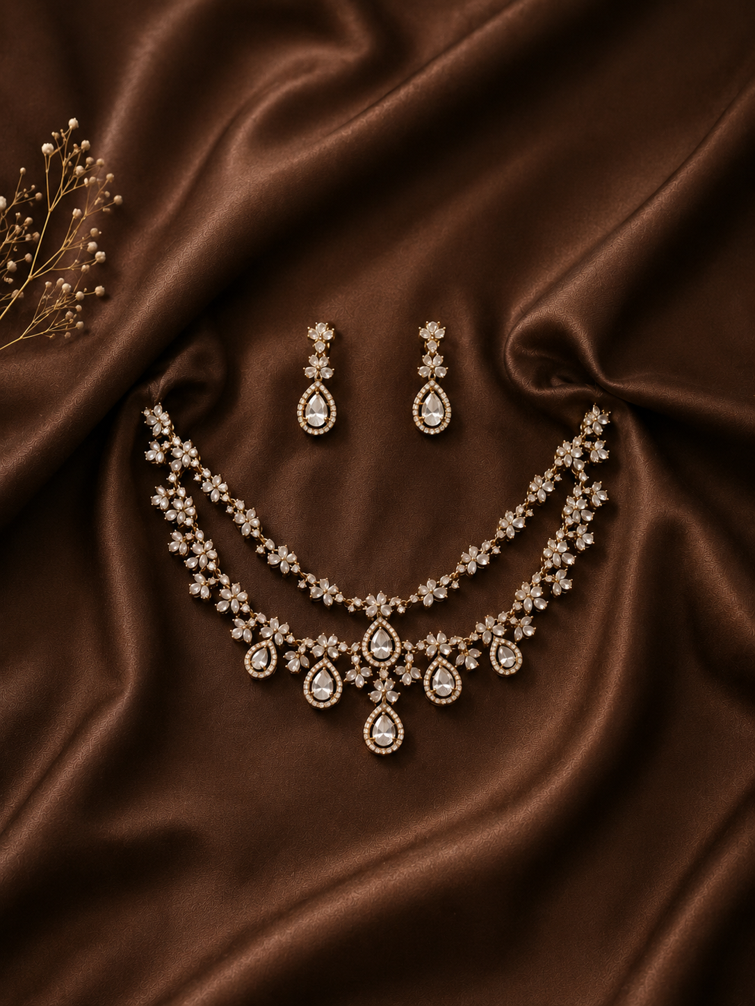 Jewelry set with necklace and earrings on brown satin fabric