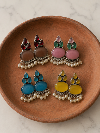 Set of colorful earrings on a brown plate with a marble background