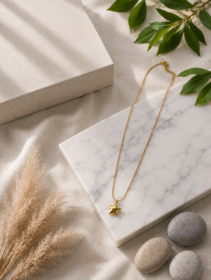 Here is a comprehensive, one-paragraph alt text for **GN016_star chain.png**, balancing descriptive detail with conciseness for an e-commerce or catalog setting:

> A close-up photograph focusing on a woman's neck and collarbone, highlighting a minimalist gold necklace. The piece features a delicate, thin gold chain carrying a polished, three-dimensional five-pointed star pendant that rests flat against her skin. The model, showing her jawline, soft dark updos, and a cream strapless top, is captured in warm