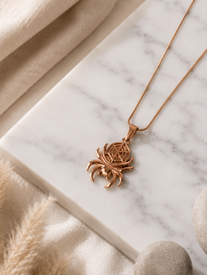 A polished rose gold-toned pendant necklace shaped like a spider, featuring curved legs and an intricate geometric web design cutout on the body. The pendant hangs from a thin, smooth snake chain and is displayed both as an aesthetic flat-lay on a white marble surface and draped over a neutral jewelry mannequin bust.