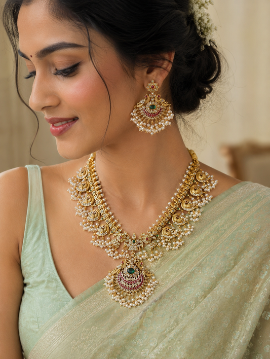 A side profile of a bride wearing the Bharathi Andhra Bridal Guttapusalu Necklace set with a light green saree, showcasing the intricate pearl clusters, ruby-emerald traditional pendant, and matching statement earrings.