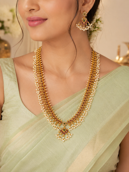 Close-up of a model wearing the Manushya Traditional Guttapusalu Long Haram Set paired with a pastel green silk saree, showcasing the length of the traditional necklace and its matching statement earrings.