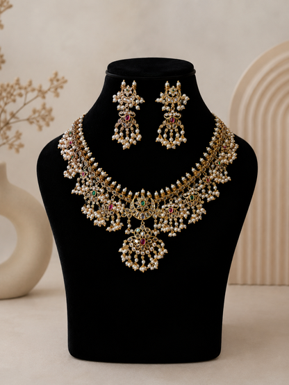 Ornate necklace and earrings set on a black mannequin bust with a neutral background