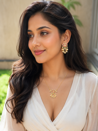 Woman wearing gold jewelry with a neutral background