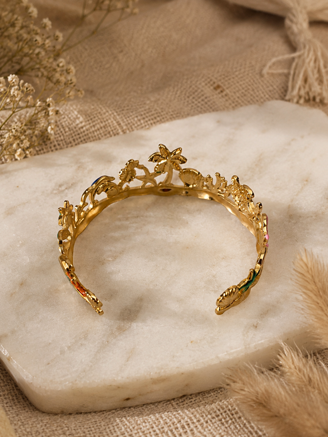 Gold tiara with decorative elements on a marble surface