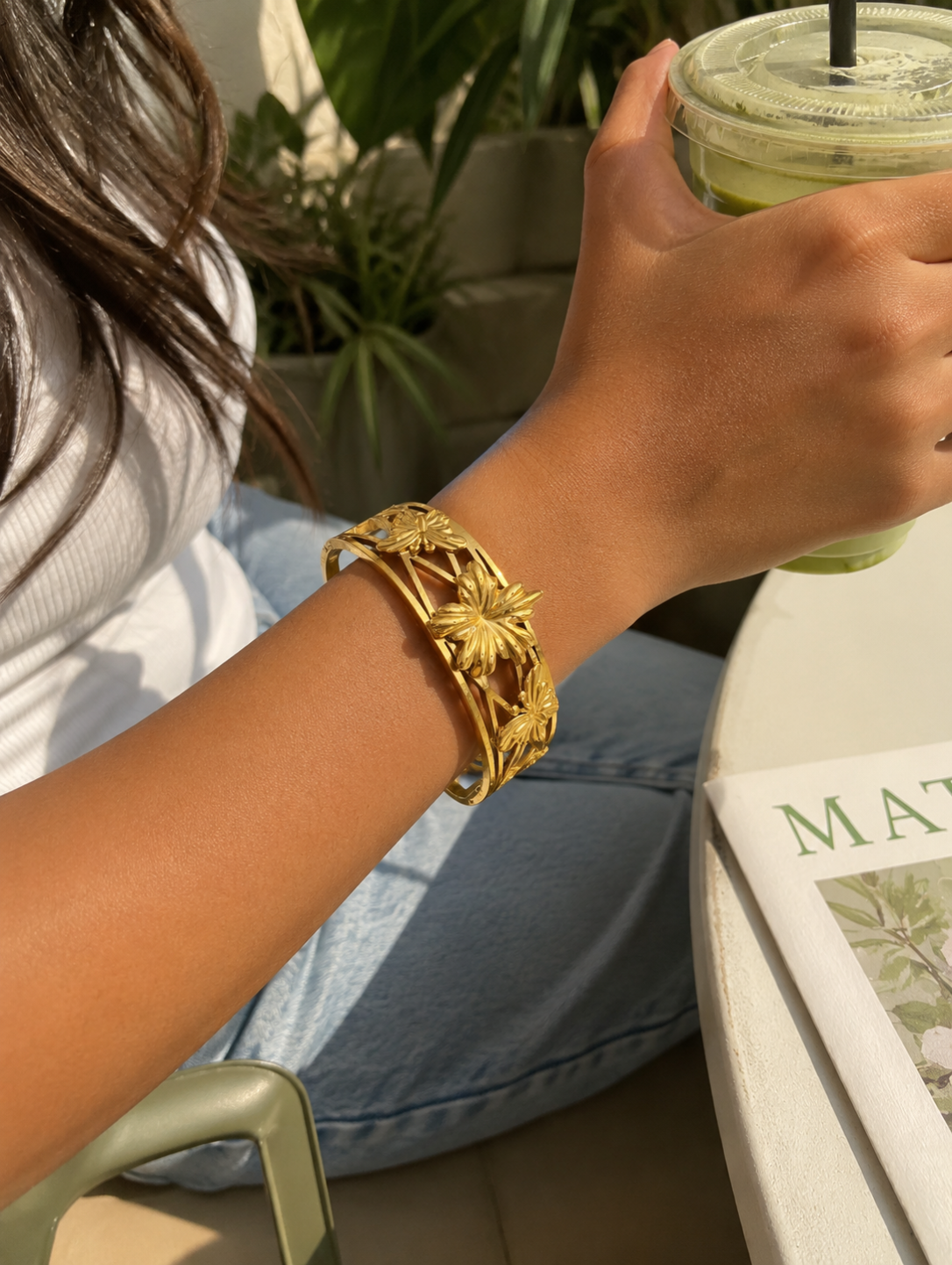 Antica Designs premium warm gold-toned Petal Arc statement kada featuring sculpted 3D floral and butterfly elements on an open-frame design.