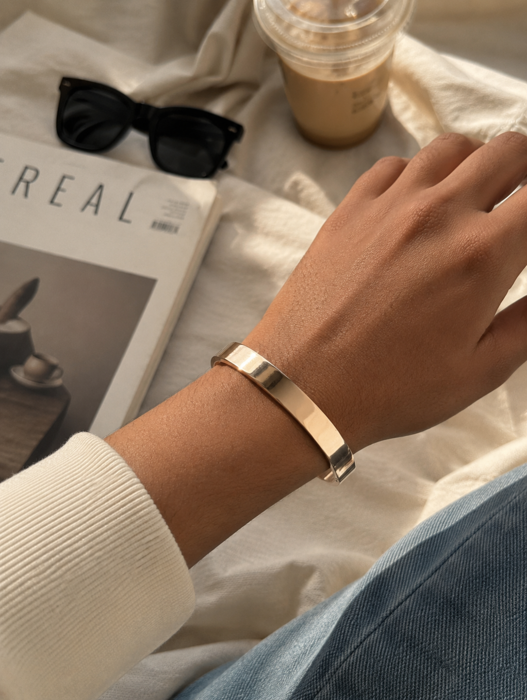 Antica Designs premium high-polish flat gold-toned unisex kada bracelet, styled on a wrist in a clean, modern aesthetic setting.