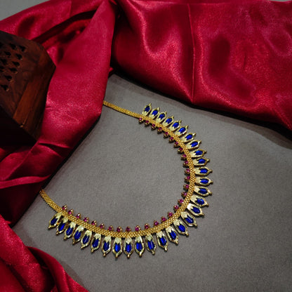Decorative necklace with blue and red stones on a gray surface with red fabric