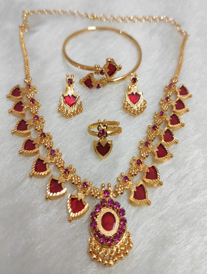 Gold jewelry set with red gemstones on a white background