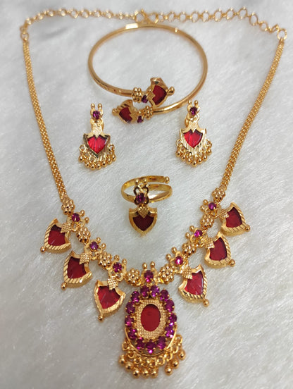 Gold jewelry set with red stones on a white background