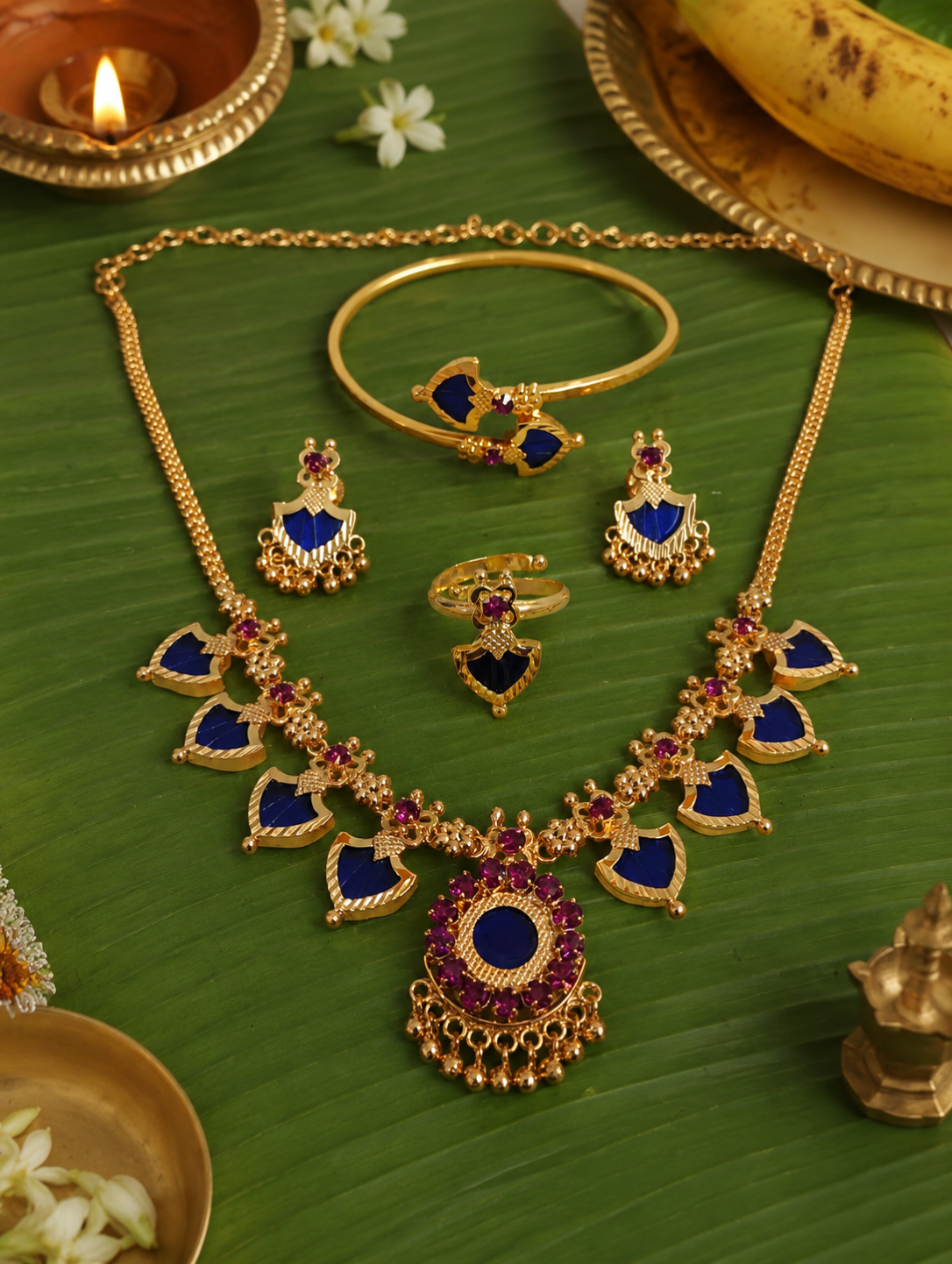 Celebrate the timeless beauty of Kerala tradition with this elegant Palakka Combo Jewelry Set, featuring a matching necklace, earrings, adjustable ring, and kada. Crafted with a premium gold finish and intricate detailing, this lightweight set is perfect for weddings, festivals, temple visits, and ethnic occasions. A graceful addition to every traditional jewelry collection.