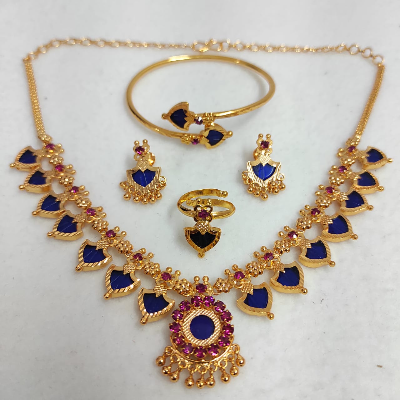 Jewelry set with necklace, earrings, and bracelet on a white background