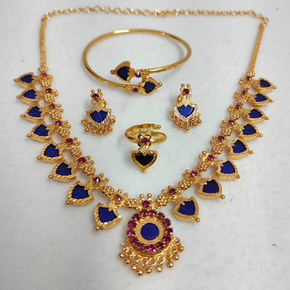 Gold jewelry set with blue and red stones on a white background