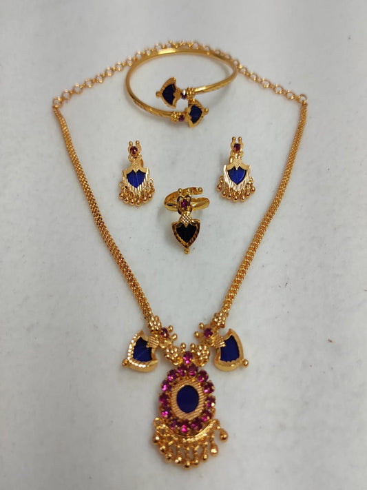 Nandika 2 Charm gold-plated jewelry set featuring a traditional necklace, matching earrings, a ring, and a bangle with deep sapphire blue and ruby stones on a white surface.