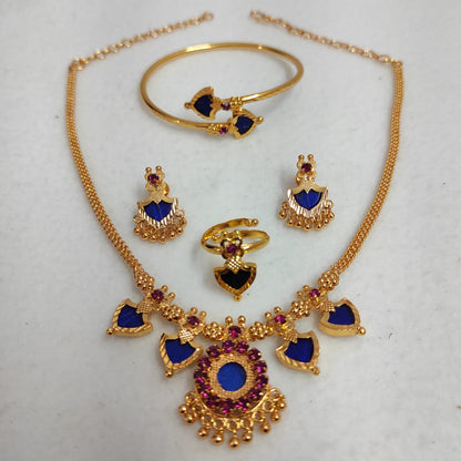 Gold jewelry set with blue and red stones on a white background