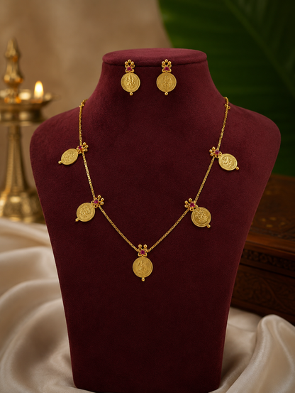 Gold necklace and earrings on a mannequin bust with a soft background
