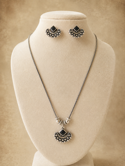 Jewelry set with necklace and earrings on a mannequin bust against a beige background