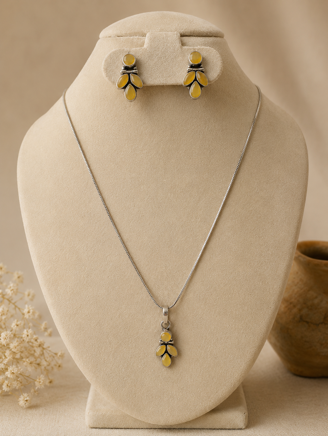 Jewelry set with necklace and earrings on a beige stand