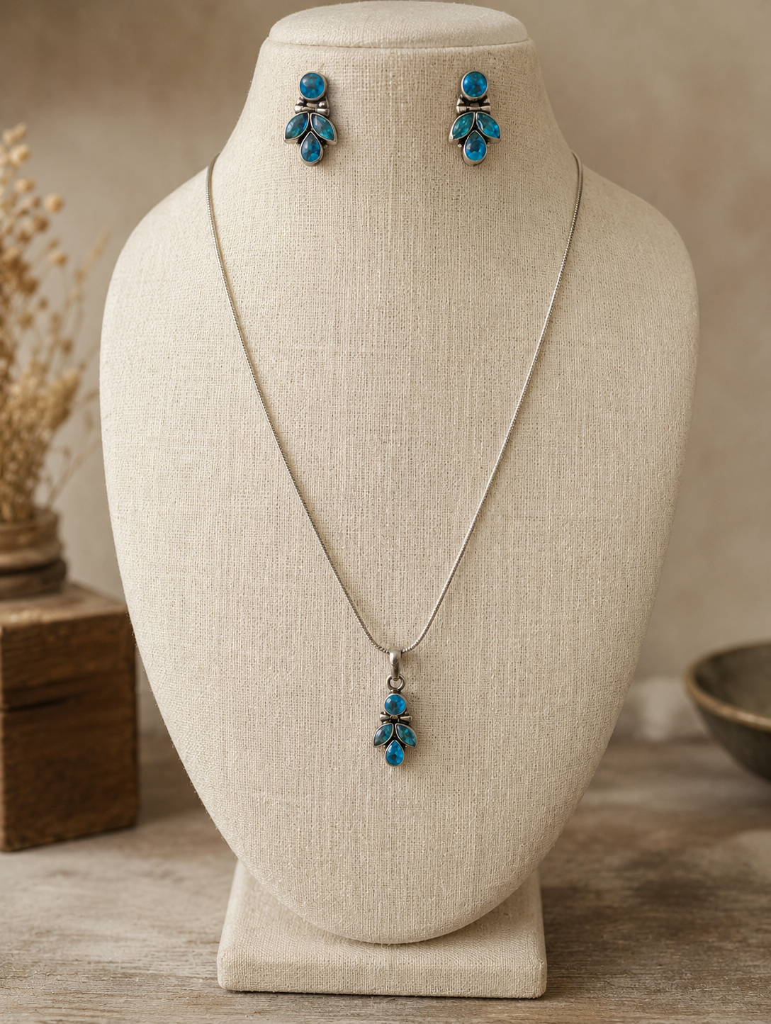 Jewelry set with necklace and earrings on a beige mannequin bust.