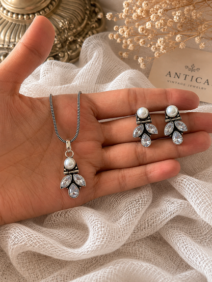 Pearl and crystal jewelry set on a hand with 'Antica' brand name in the background
