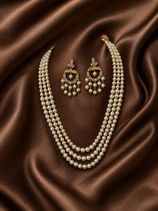 Pearl necklace and earrings on brown satin fabric