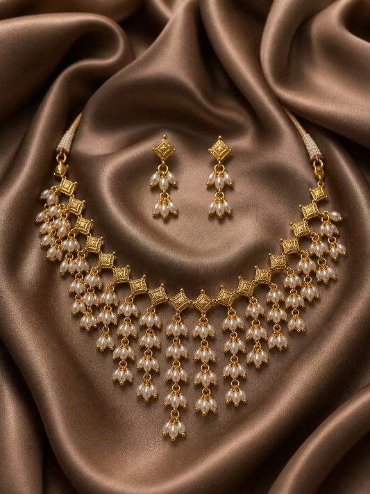 Gold necklace and earrings set on brown satin fabric
