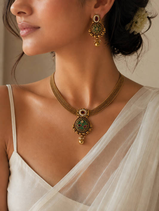 Woman wearing a gold necklace and earrings with a white garment