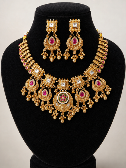 Gold necklace and earrings set on a black mannequin bust with a plain background
