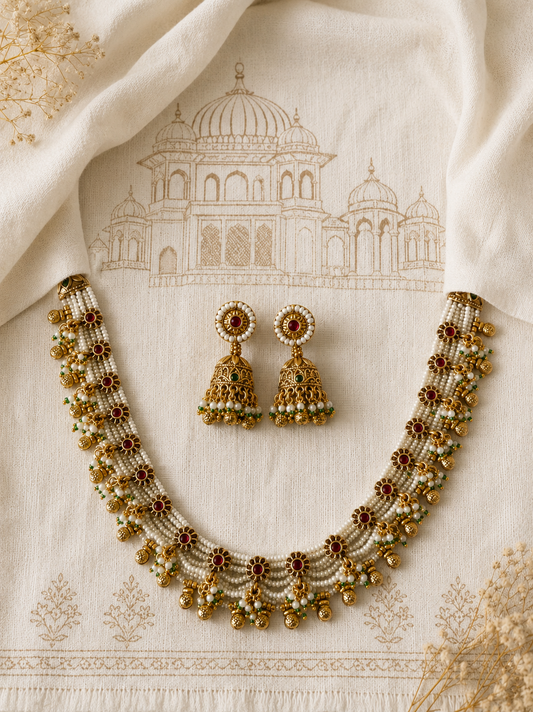Indian bridal antique gold multi-strand pearl haar necklace set with matching ruby and gold bead Jhumkas for festive and wedding celebrations.