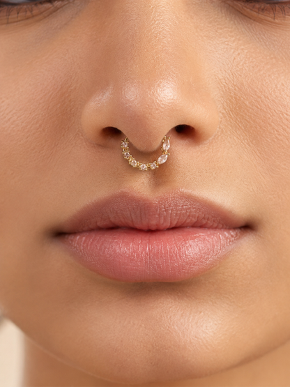 Close-up view of a model wearing the gold-tone festive nose ring as a septum ring, highlighting the unique layout of sparkling round and marquise-cut stones.