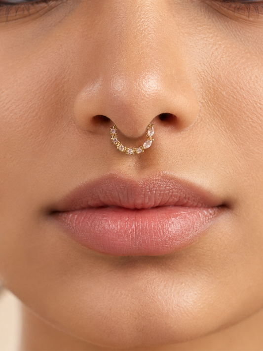 Close-up view of a model wearing the gold-tone festive nose ring as a septum ring, highlighting the unique layout of sparkling round and marquise-cut stones.