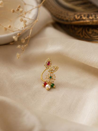 Gold-plated press-on nose ring with CZ stones, ruby red and emerald green accents, and pearl bead hanging.